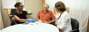 men and cancer survivor patient eating with help of physicians at brooks rehab