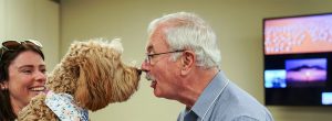 patient Joe Schmidt talking to a dog at brooks rehab in theraphy