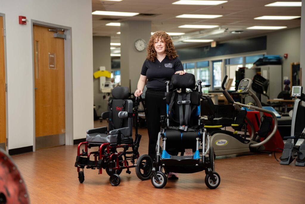 Brooks employee standing with two wheelshairs
