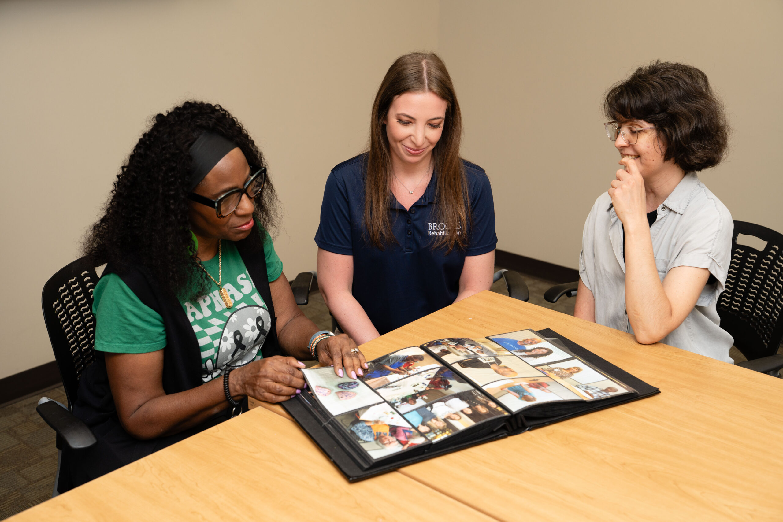 aphasia center members at a table looking at photo album