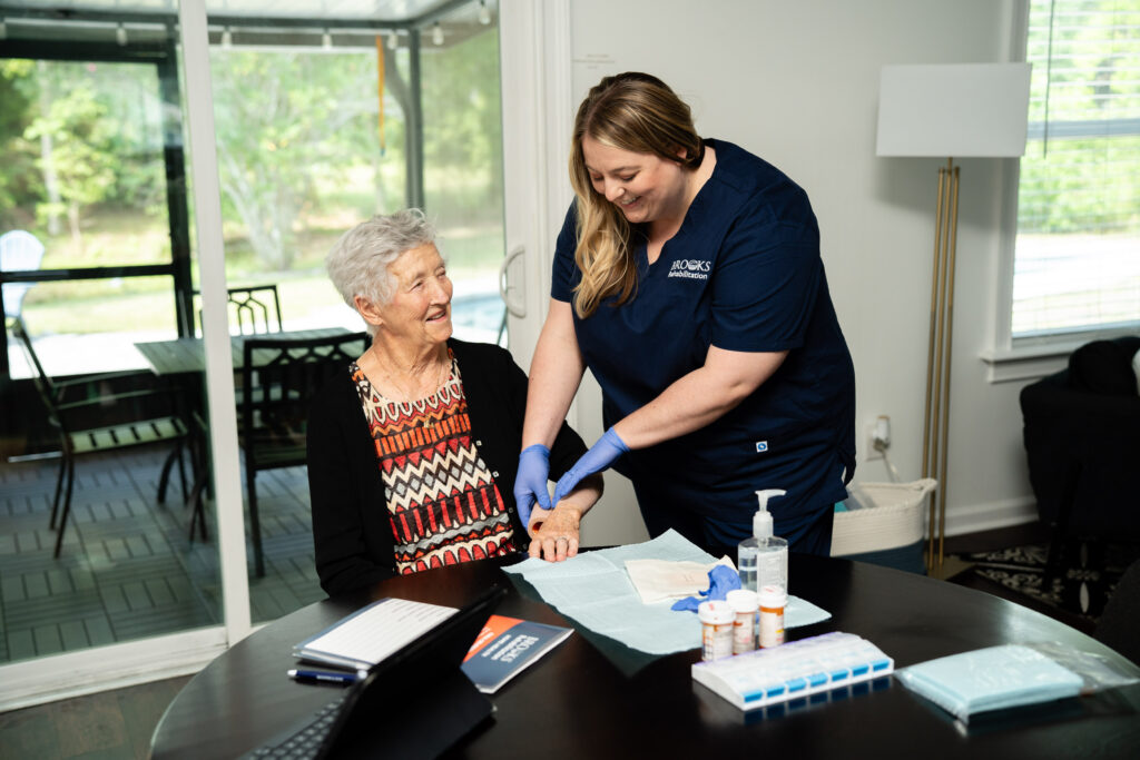home health therapist helping patient sitting at a table