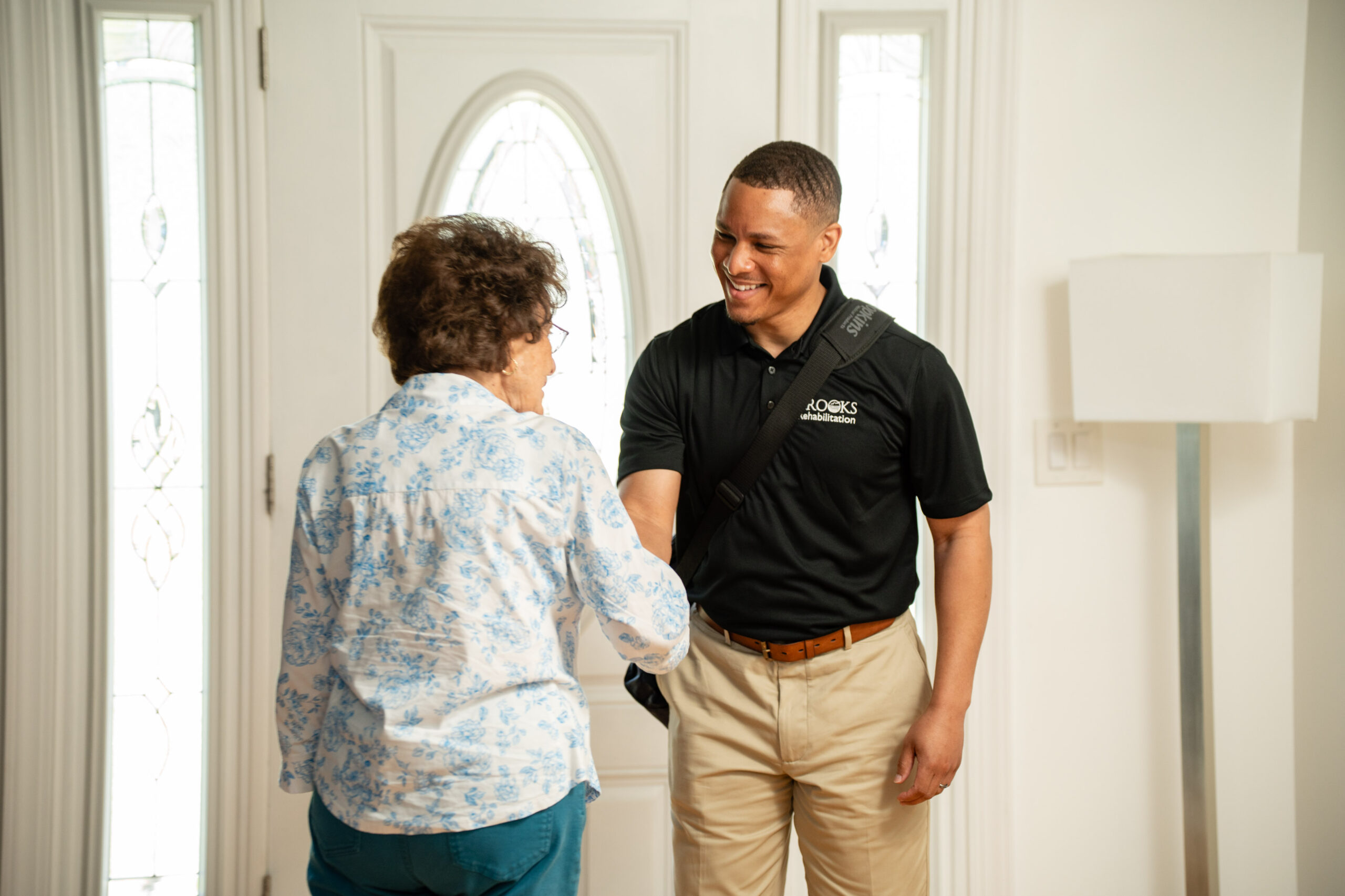 home health therapist shaking hands with patient