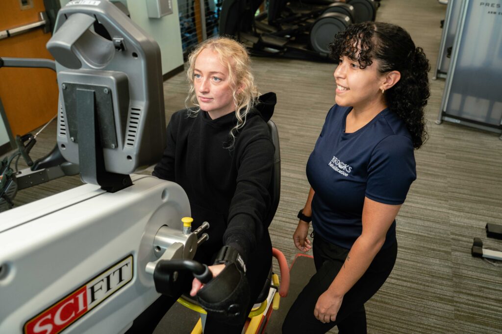 Therapist helping patient on exercise machine
