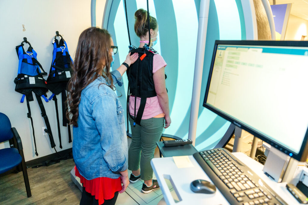 a clinician monitors a patient's balance using technology.