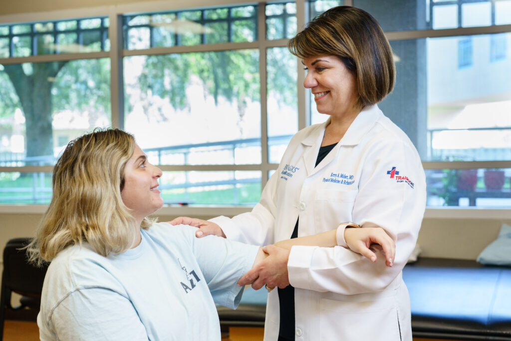 dr maher treating a young woman in a therapy gym.