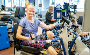 Stroke patient using machine and smiling at the camera