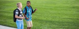 kids talking on the way to school with backpacks