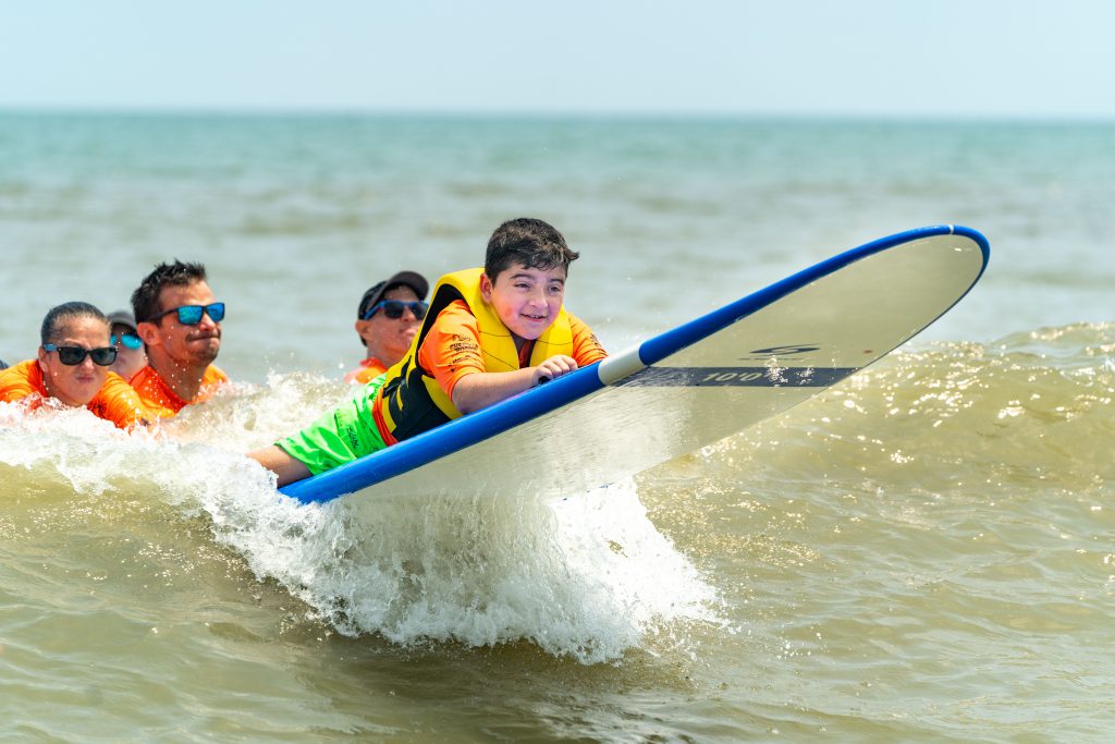 Boy Surfing at the brooks adaptive surfing event