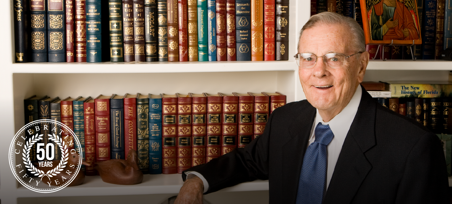 Dr. Brooks Poses in Front of Bookcase