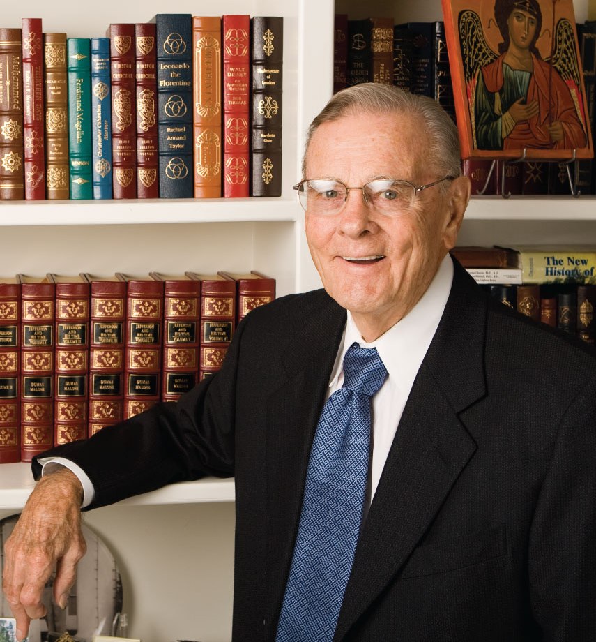 Dr. Brooks Brown in front of book case