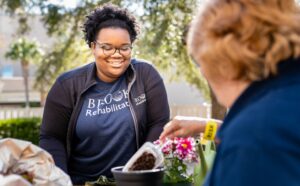 A woman stands in the sun while gardening