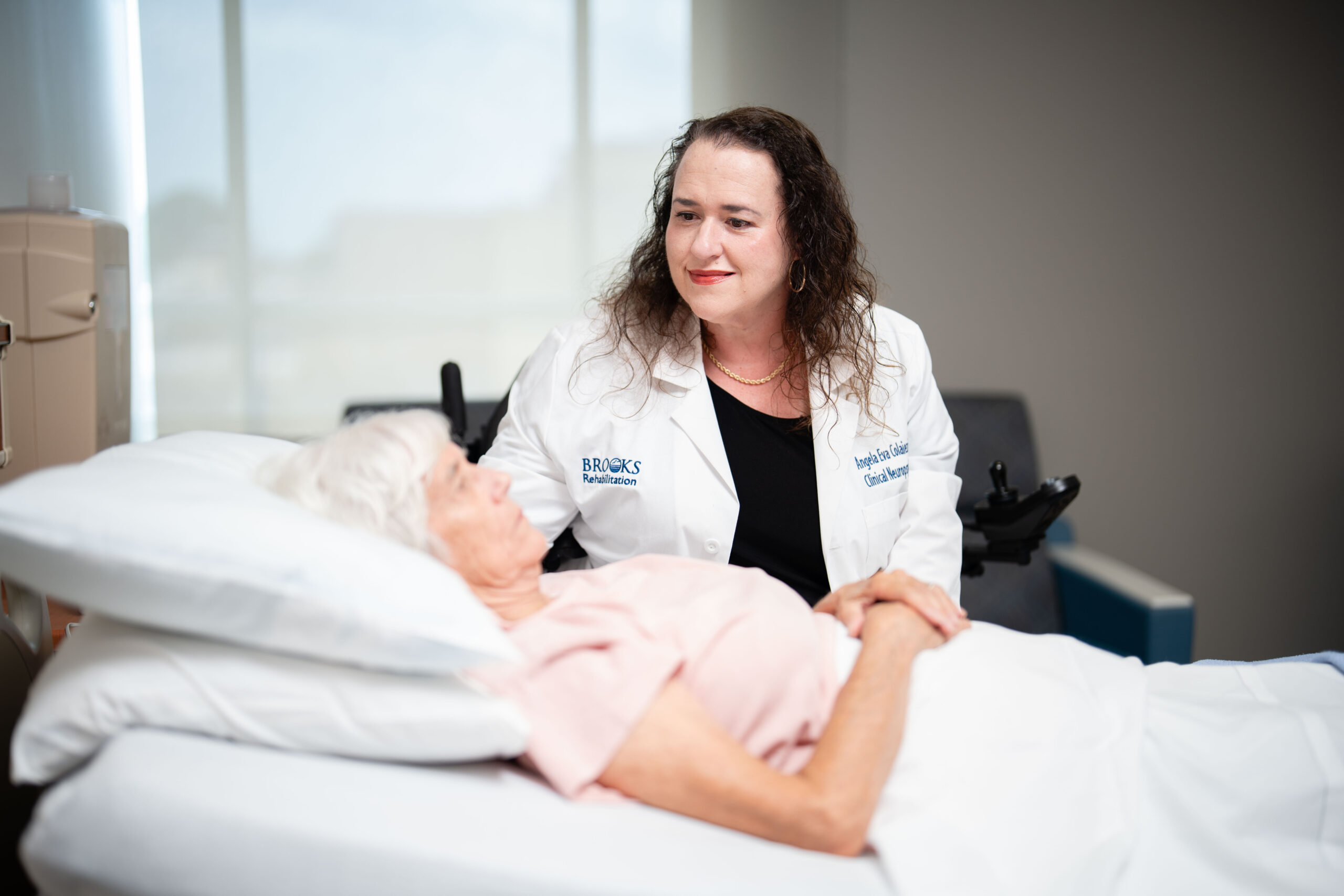 Dr. Colaiezzi examines a DoC patient in their hospital bed.