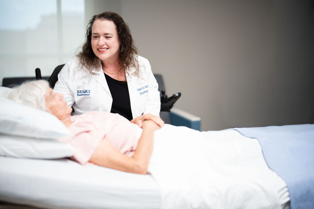 Brooks neuropsychologist, evaluates a disorders of consciousness patient in the hospital bed.