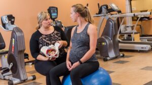 A pregnant woman speaks to another woman holding anatomical display