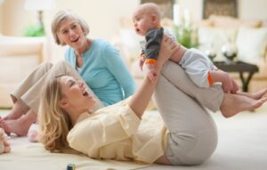 Woman playing with a baby while an older woman looks on