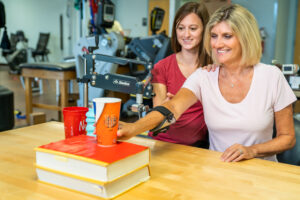 Occupational therapist working with a woman moving cups