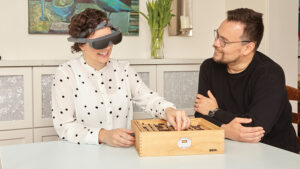 Woman using a low vision aid while chatting and smiling with a man