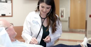 Dr. List using stethoscope on patient in a hospital bed