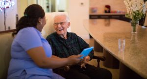 Patient and nurse smiling and looking at a tablet