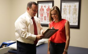 Dr. Jason Beneciuk showing something on a clipboard