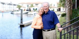 Lynne and Gary Sneed embracing on the shore of a lake