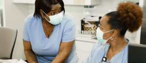 Two Nurses chatting at a desk