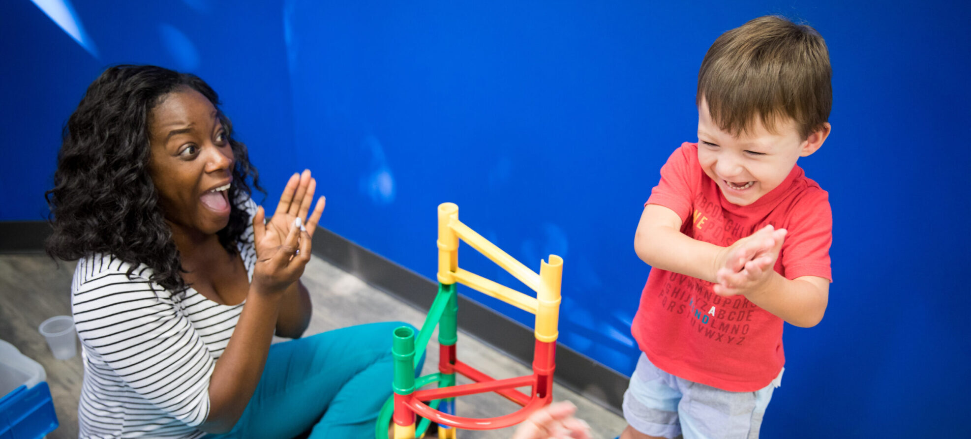 Pediatric patient playing games with a woman at Brooks