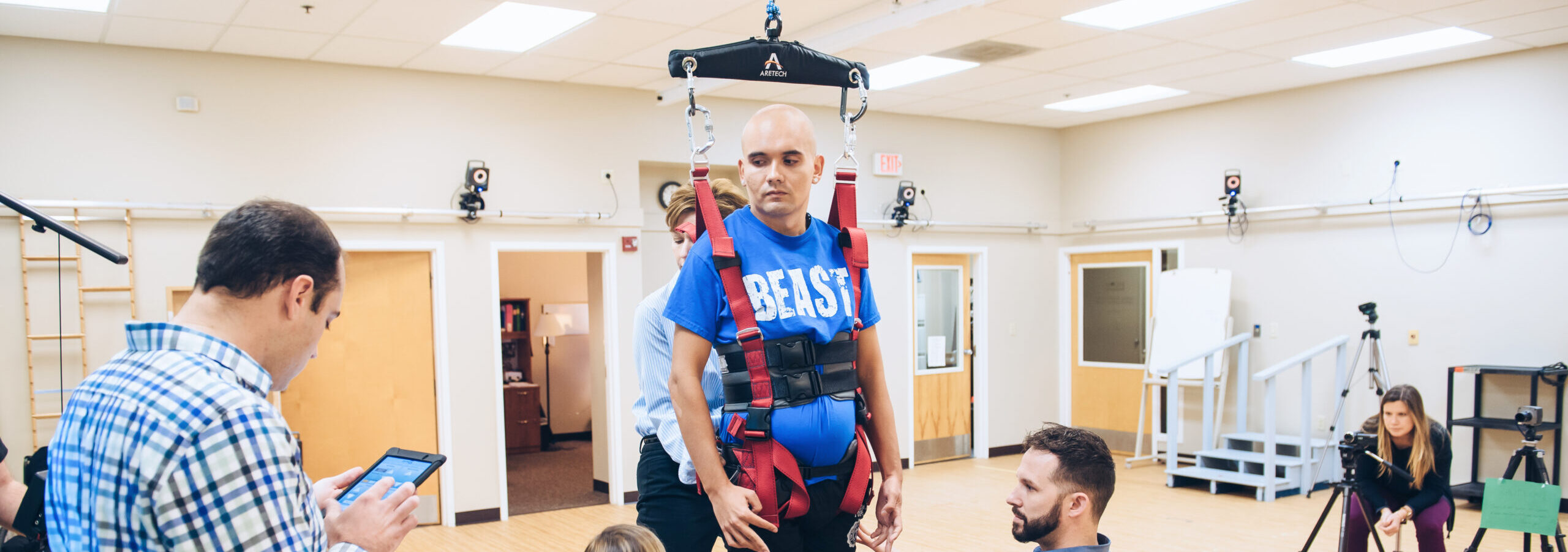 Patient in a ceiling mounted tracker while researchers examine him