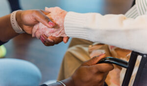 Arthritis patient holding hands with a staff member