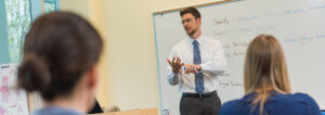 Instructor giving a lecture in front of a whiteboard at IHL