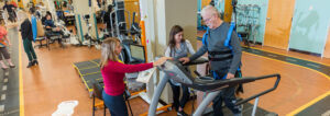 Patient using treadmill and staff inside the Neuro Recover Center