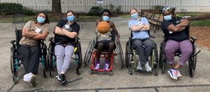 Wheelchair basketball players in masks posing for the camera