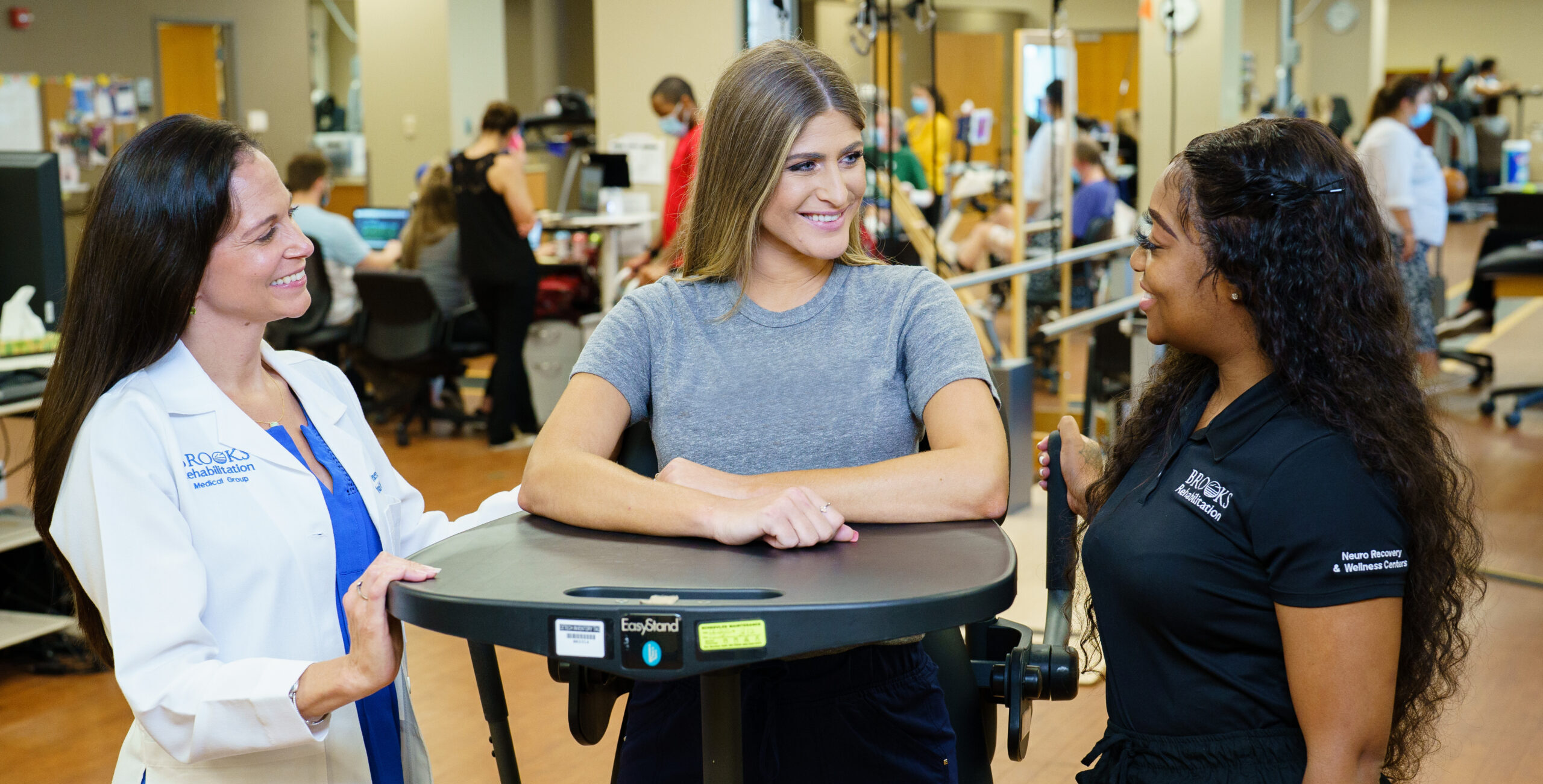 Dr. Tonuzi and staff member chatting and smiling with a patient