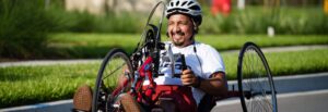 Carlos biking down the road and smiling