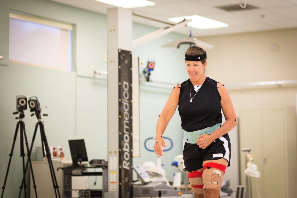 a woman is connected to a motion analysis machine to measure movement.