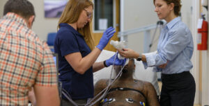 Clinicians providing breathing therapy to a patient with a spinal cord injury