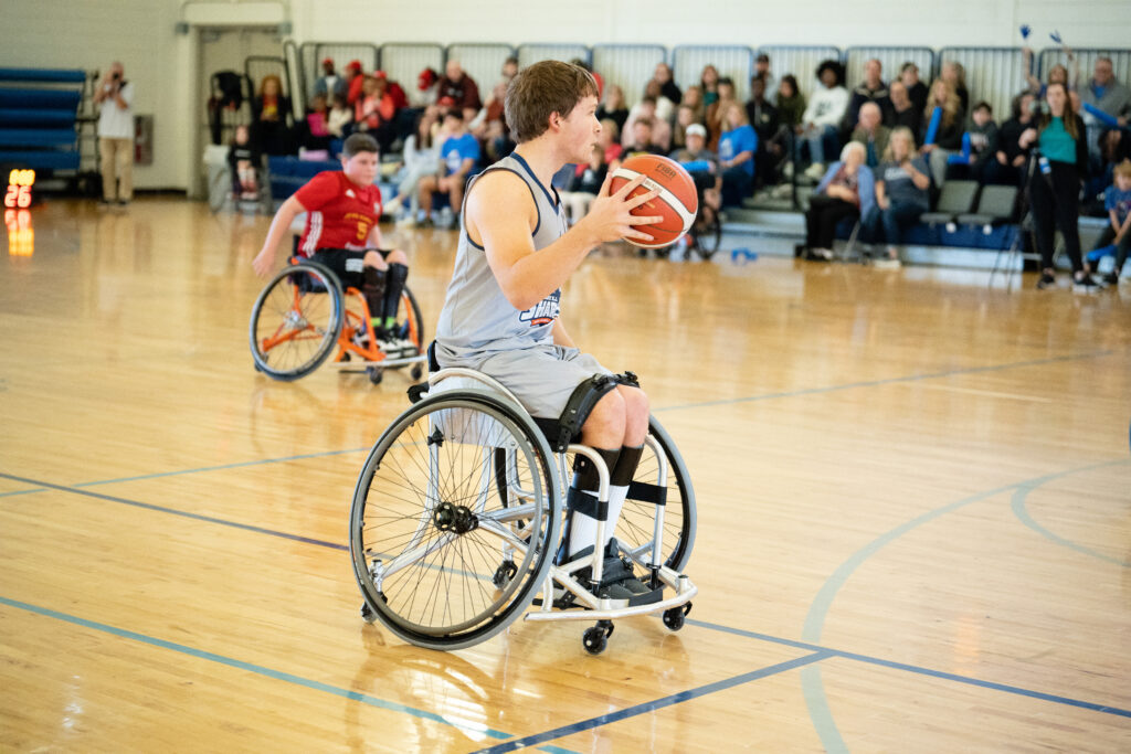 a child with disabilities uses an adaptive wheelchair to play basketball.