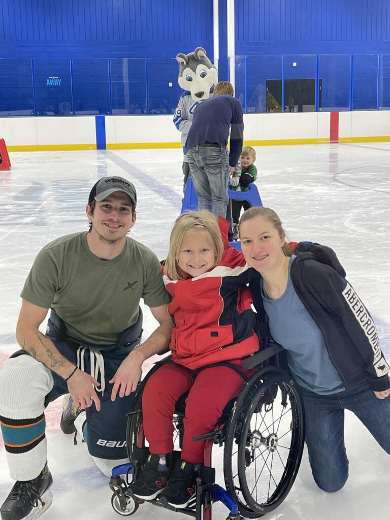Kid posing with family at the skating rink