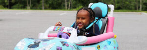 Kid smiling while cruising in a toy car