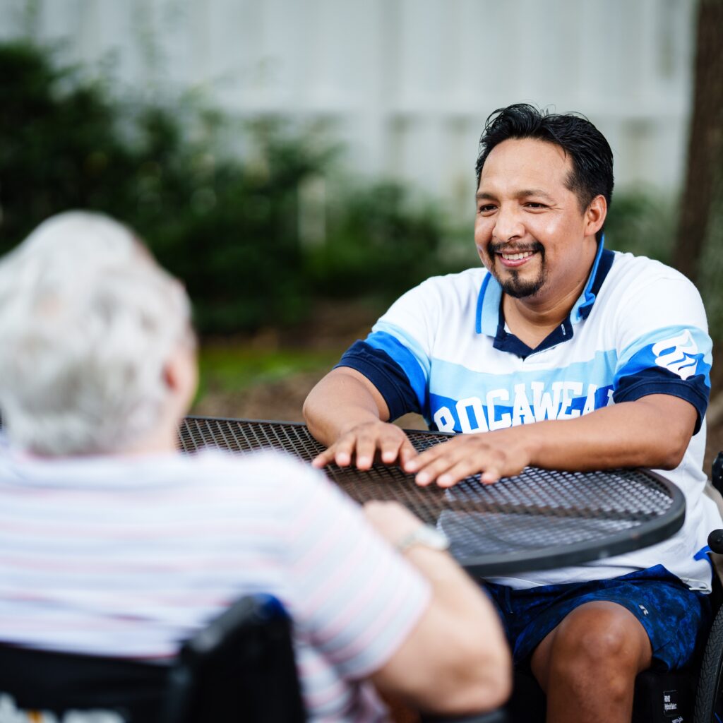 Two people enjoying a conversation at a table outside