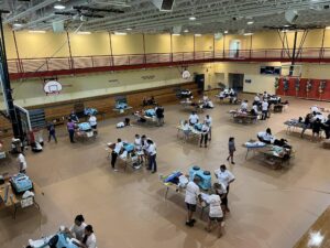 Volunteers assemble toy mobility cars for kids.