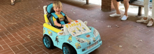 a local child receives an adaptive toy car to help with mobility issues.