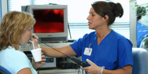 An speech language pathologist performs a swallowing test on a patient.