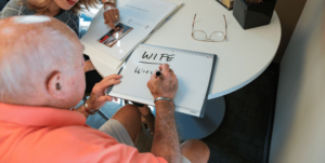 Aphasia patient spells out "wife" on whiteboard as an alternative method to communicate.