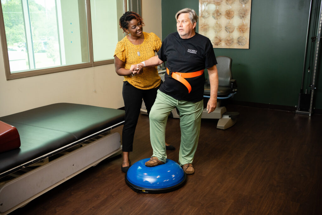 Clinician works with an elderly patient during orthopedic rehabilitation at a skilled nursing center. 