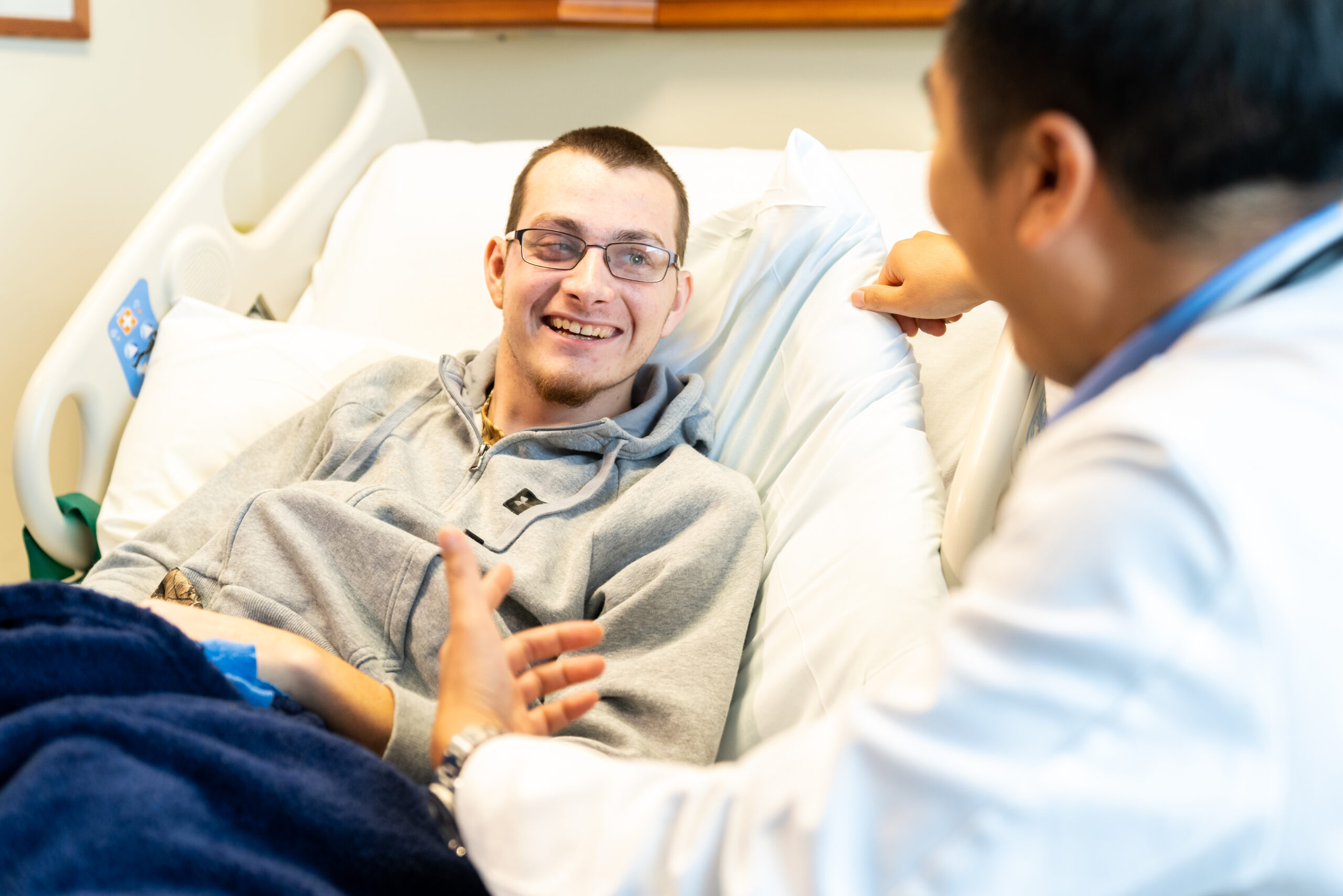 Dr. Ngo, medical director of Brooks Rehabilitation's brain injury program, visit with a brain injury patient.