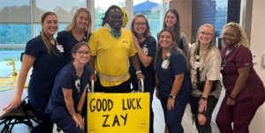 Zay Brown walks out of Bartram Campus hospital after a spinal cord injury surrounded by his recovery team