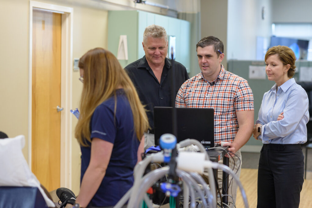 Brooks and UF research teams looking at data on a computer screen.
