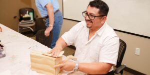 A person with aphasia works on a craft project at an Aphasia Center.