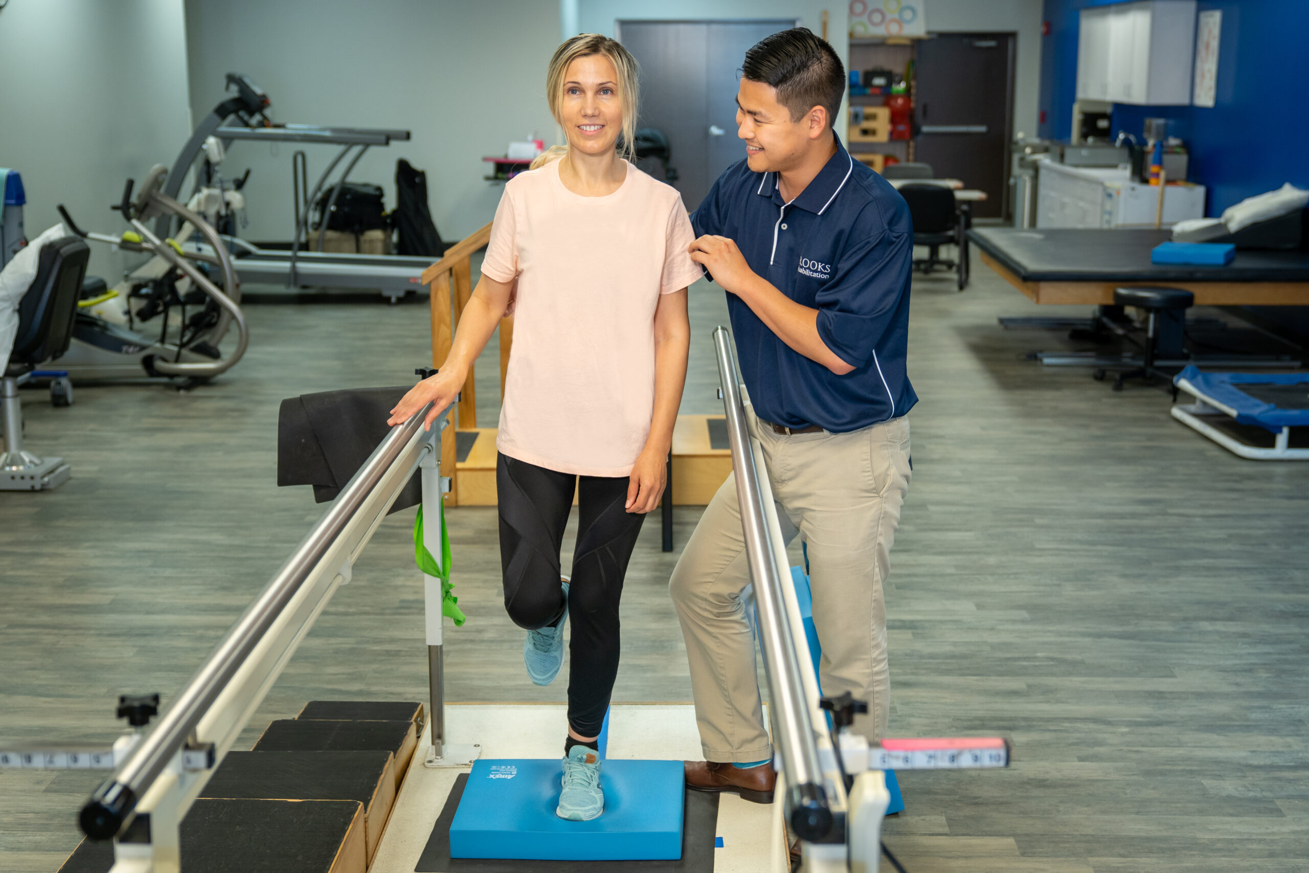 A physical therapist at Brooks works with a woman patients on balance exercises.